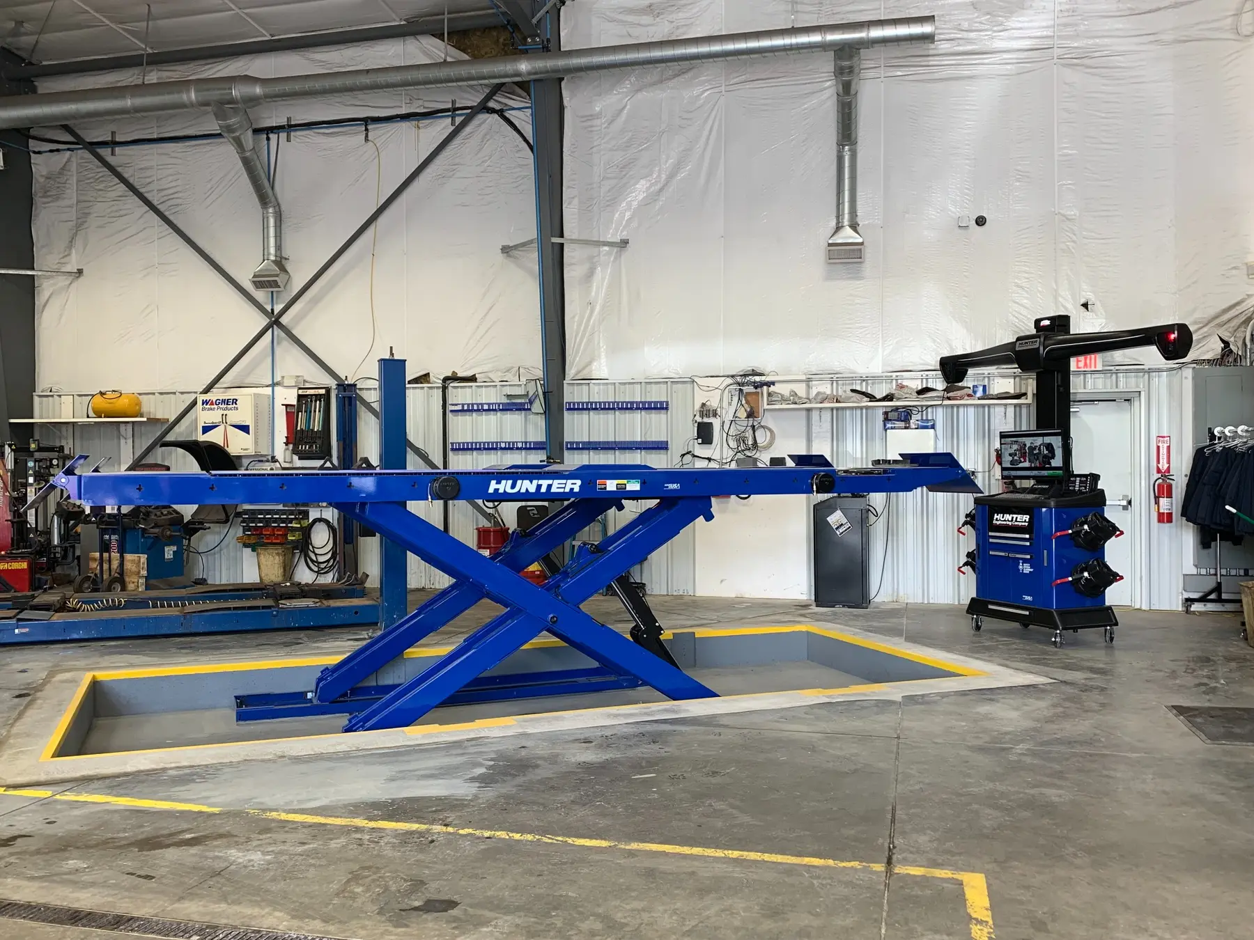 Same service bay after installation of a recessed blue Hunter lift system