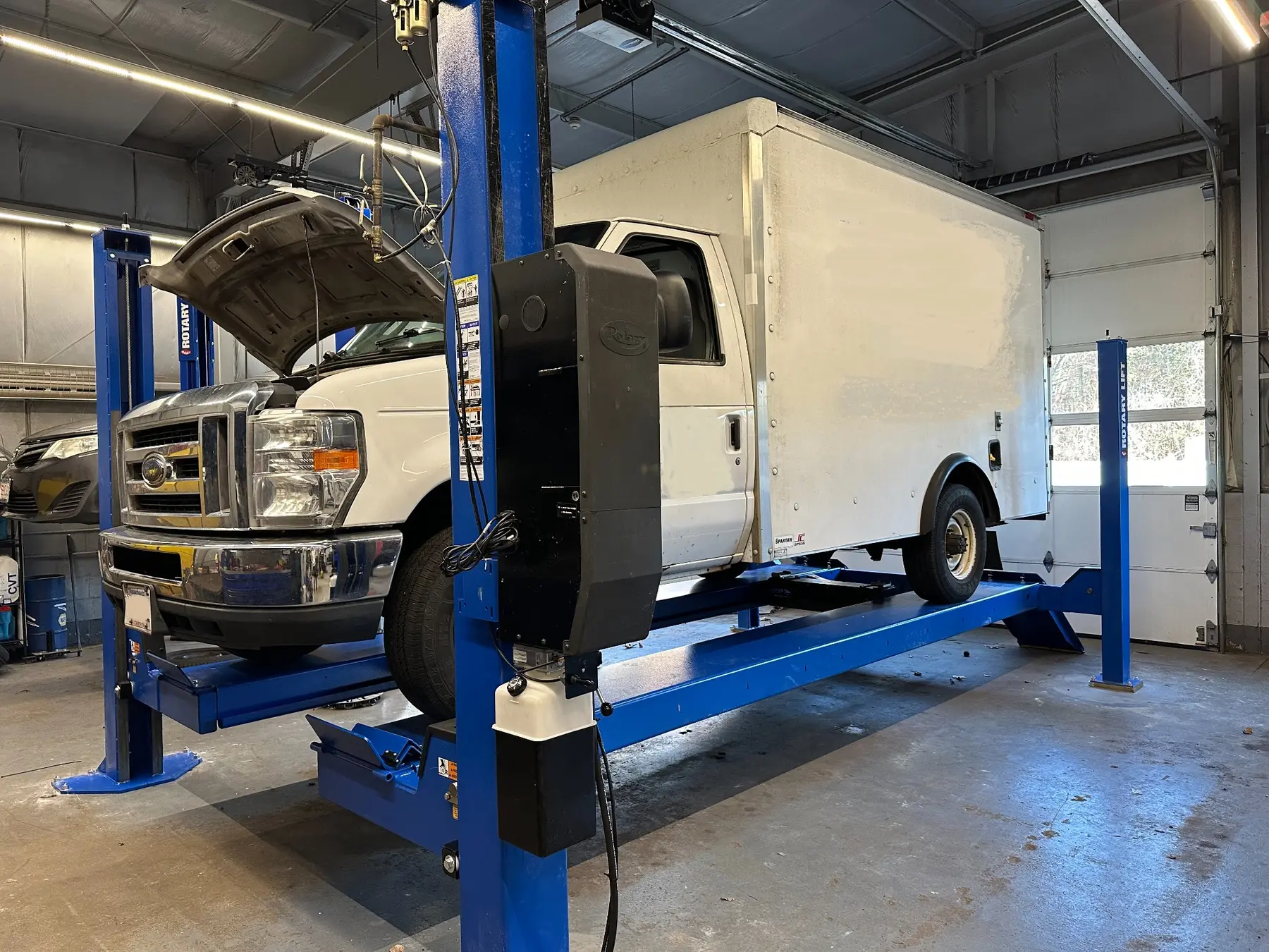 Box truck raised on a commercial vehicle lift