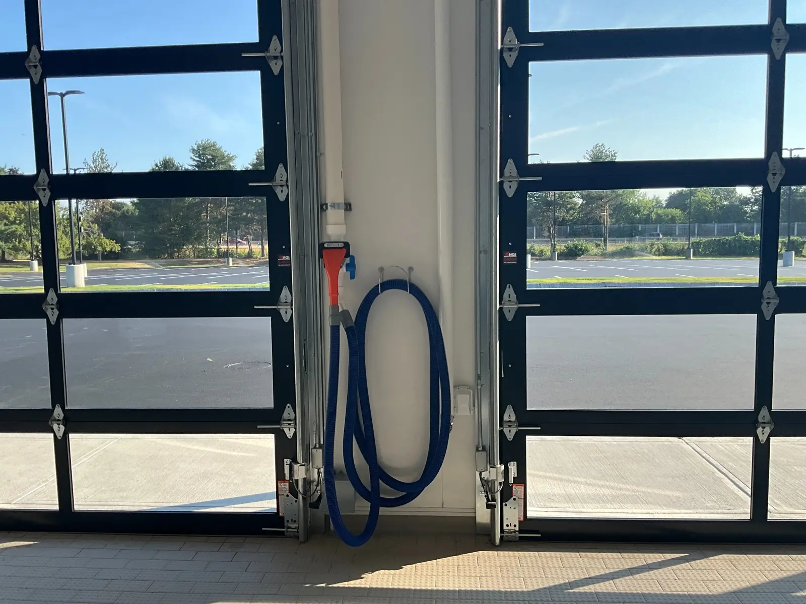 Vehicle exhaust extraction hose installed between service bay doors